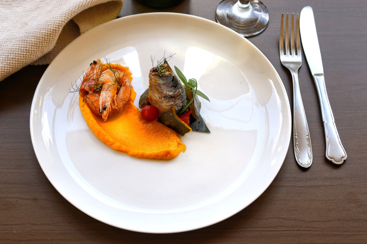 hero-img-02 A beautifully plated seafood dish with shrimp and fish on an elegant plate, captured in Oporto.